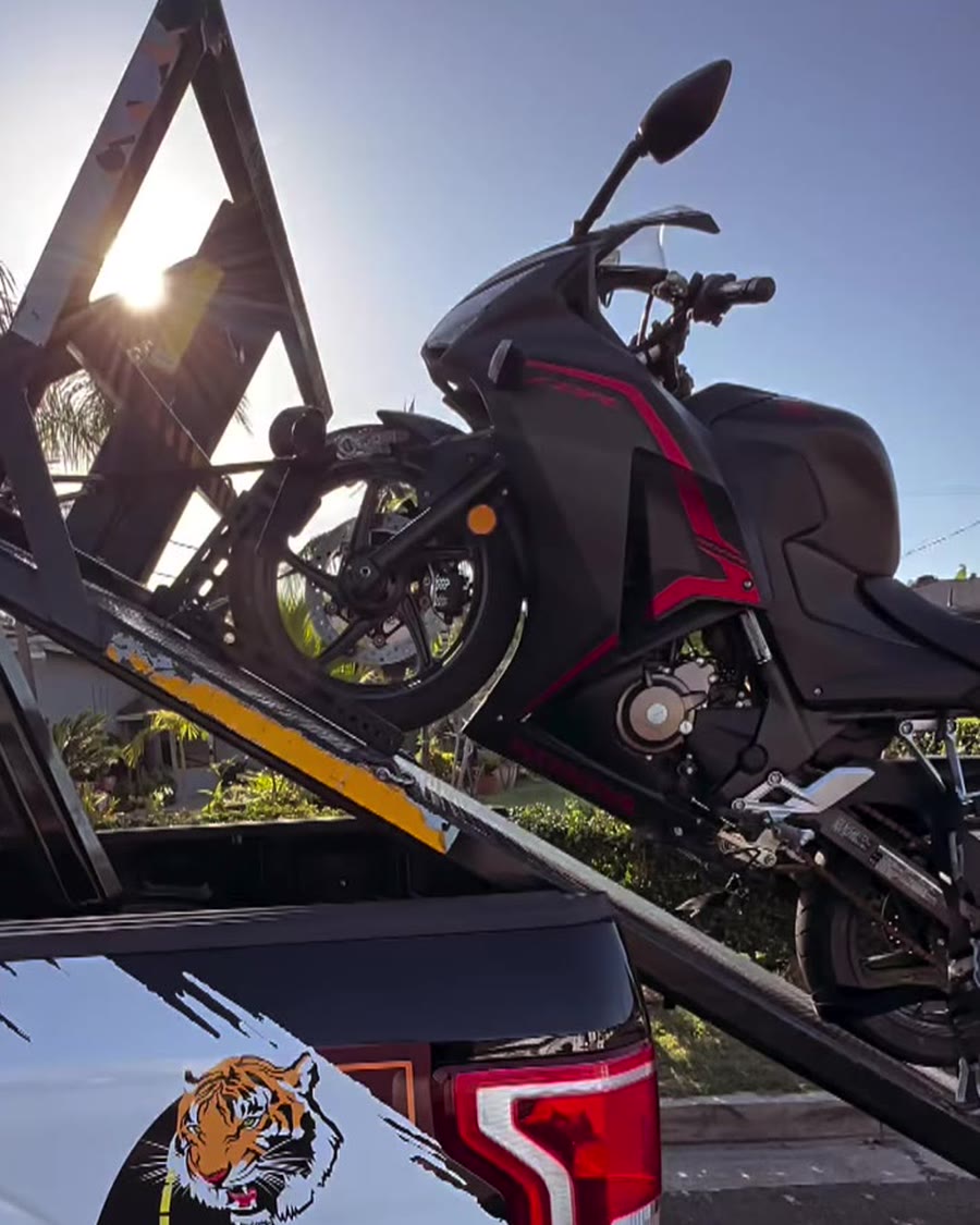 Black and red sportbike on Law Tigers branded black truck lift