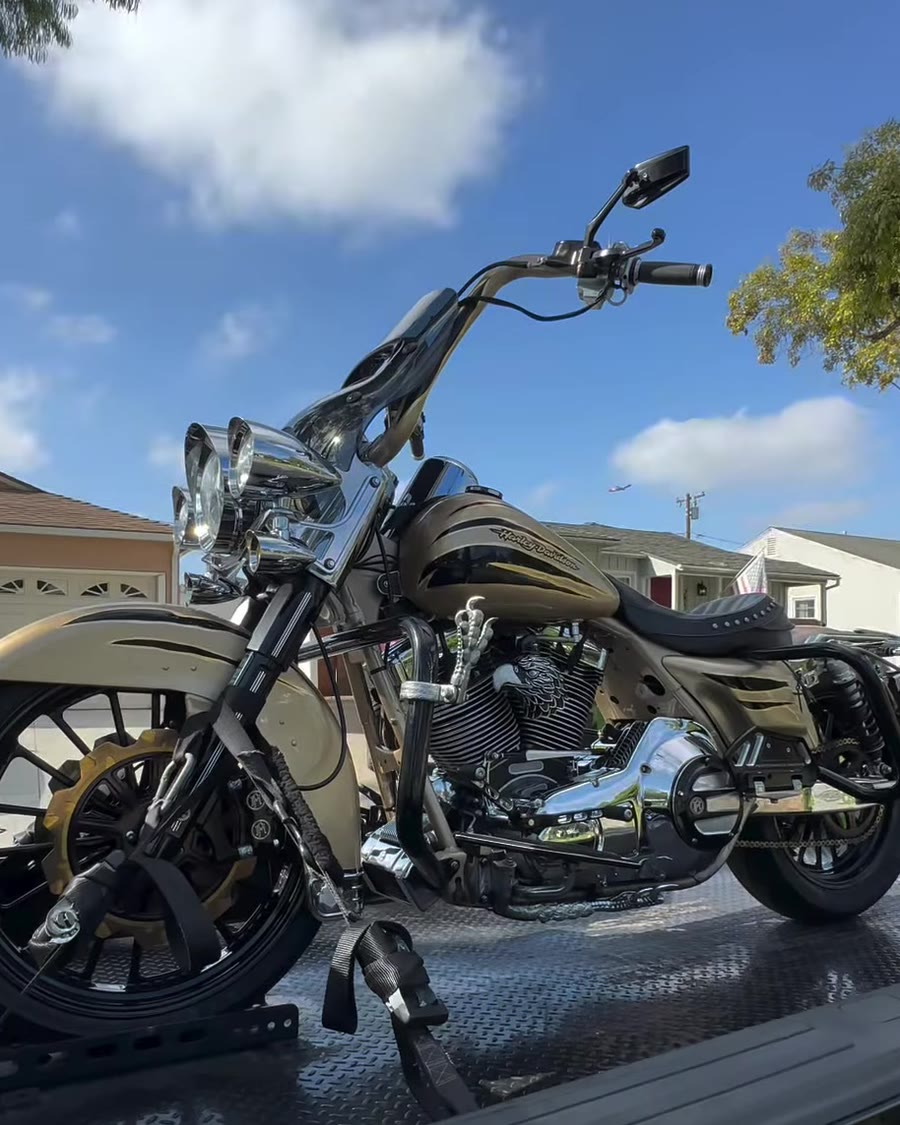 Champagne gold Harley cruiser strapped on black diamond-plate bed